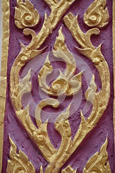 Golden Thai pattern sculpture on the temple wall