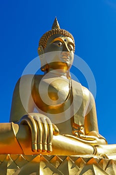 Golden Thailand Buddha in Hinayana tradition in pure blue sky