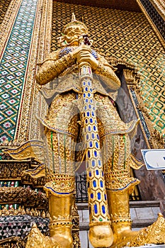 A golden thotsakhirithon giant demon guarding an exit to the Temple of Emerald Buddha