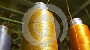 Golden thread uncoiling from spool by machine tool in shop