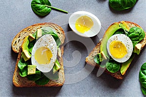 Golden toast with avocado and chicken egg and basil leaves