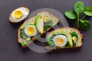 Golden toast with avocado and chicken egg and basil leaves