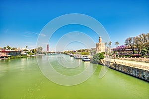 Golden Tower (Torre del Oro) with Guadalquivir River in Seville during a Sunny Day, Andalusia photo