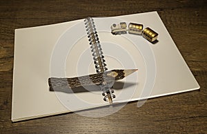 Golden train on blank notebook with one wooden pencil