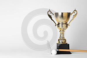 Golden trophy cup, golf club and ball on white background.