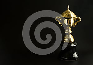 Golden trophy over black background. Winning awards with copy space for text and design.