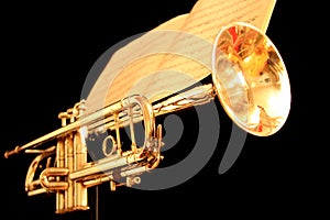 Golden Trumpet with Sheet Music on Black Background