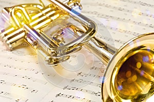 Golden trumpet on sheet music with scenic reflections and lens flare