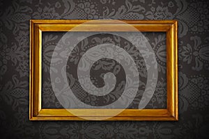 Golden vintage empty frame on floral wallpaper