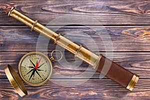 Golden Vintage Telescope Spyglass with Compass over Wooden Table
