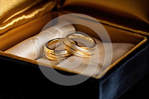 golden wedding bands nestled in an open velvet box