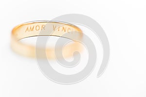 Golden wedding ring isolated on white - amor vincit omnia engraved