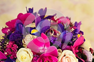 Golden wedding rings on the background of a wedding bouquet of red roses