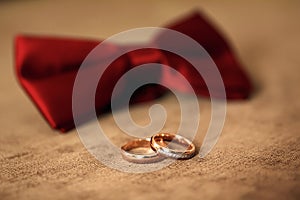 Golden wedding rings on the background of a wedding bouquet of red roses