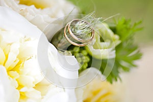 Golden wedding rings on the ear of wheat of weding bouquet