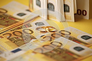 Golden wedding rings on euro banknotes background. Marriage of convenience