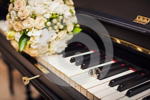 Golden wedding rings lie on the piano
