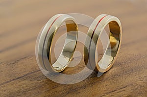 Golden wedding rings on wooden surface