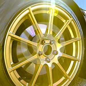 Golden wheel rim of a car on a bright sunny day