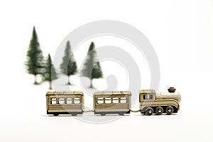 Golden wooden toy train isolated from white background and blur pine tree