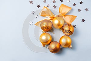 Golden and yellow christmas ball with ribbon on blue background with silver stars