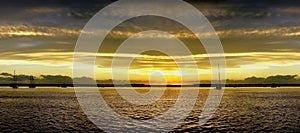 Golden yellow coloured cirrostratus cloudy coastal Sunset Seascape panorama. Australia