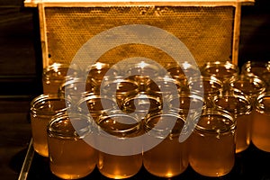 Golden yellow honey in glass jar on wooden board Closeup Copy space comp frame empty textspace