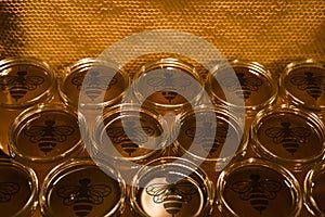 Golden yellow honey in glass jar on wooden board Closeup Copy space comp frame empty textspace with bee logo