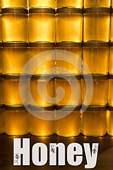 Golden yellow honey in glass jar on wooden board Closeup Copy space with textspace