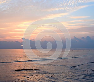 Golden Yellow Lines in Colorful Morning Sky with Bright rising Sun Horizon over Ocean with Reflection in Water