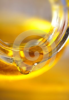 Golden yellow olive oil in glass bottle or jar