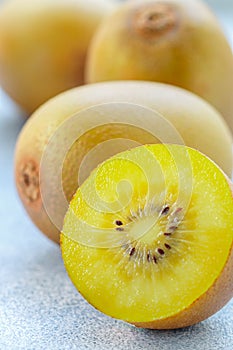 Golden yellow organic kiwi. Whole and cut ripe juicy fruits on grey background. kiwifruit