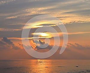 Golden Yellow Sunrays Radiating in Morning Sky with Reflection in Sea Water - Natural Skyscape Background