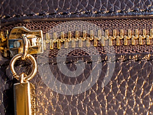 A golden zipper of a leather bag