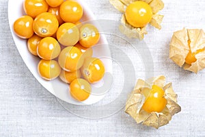 Goldenberries, Peruvian groundcherries, in white bowl on linen