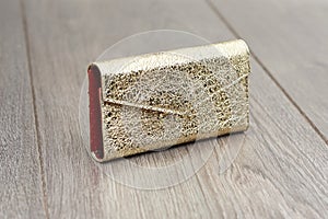 A goldy woman s clutch with cracks simmulated texture