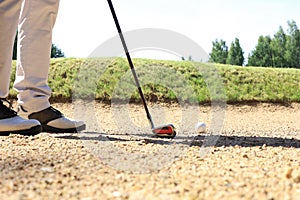 Golf approach shot with iron from fairway at sunny day