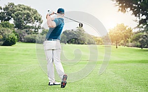 Golf, back and hobby with a sports man swinging a club on a field or course for recreation and fun. Golfing, grass and