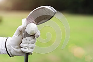 Golf background concept. Closeup golf ball and golf club on hand