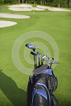 Golf bag and clubs against defocused golf course