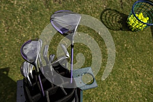 Golf bag laying in lush green grass with golf clubs