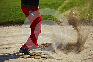 Golf ball in the air in the bunker