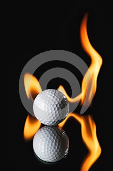 Golf ball on black background with fire