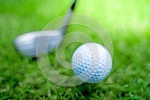 Golf ball close-up in soft focus at sunlight with Green grass. wide landscape as background ,Sport playground for golf club