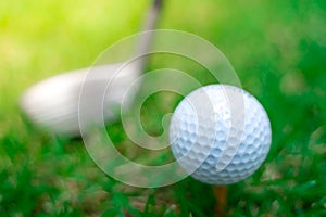 Golf ball close-up in soft focus at sunlight with Green grass. wide landscape as background ,Sport playground for golf club