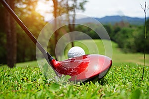 Golf ball and golf club in beautiful golf course at Thailand. Collection of golf equipment resting on green grass with green
