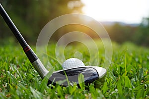 Golf ball and golf club in beautiful golf course at Thailand. Collection of golf equipment resting on green grass with green