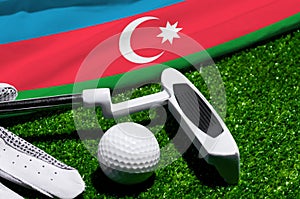 Golf ball and club with flag of Azerbaijan on green grass. Golf championship in Azerbaijan