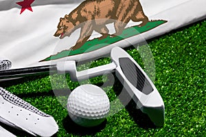 Golf ball and club with flag of California on green grass. Golf championship in California