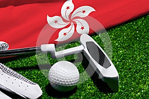 Golf ball and club with flag of Hong Kong on green grass. Golf championship in Hong Kong